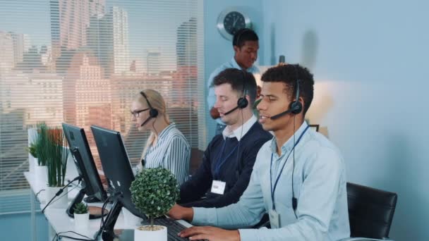 A call center fekete vezetője ajánlást ad az ügyfélszolgálati képviselőnek — Stock videók