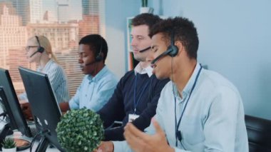 Medium shot of Frustrated and angry mixed-race call center agent talking to the client on phone