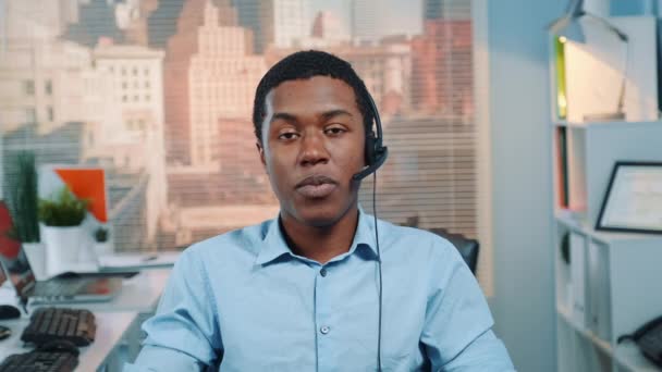 Operador de servicio al cliente negro hablando con el cliente en el centro de llamadas — Vídeos de Stock