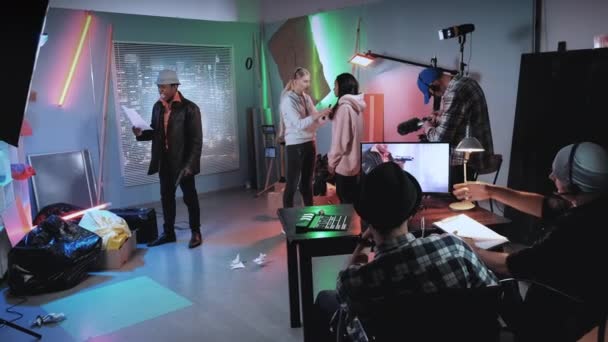 Gemengde wedstrijdsterren en crew bereiden zich voor op de scène in de moderne filmstudio — Stockvideo