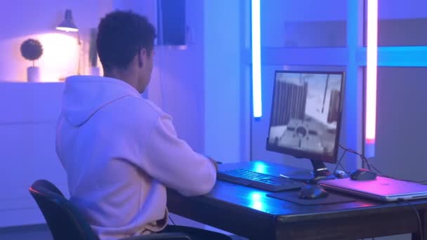 Back view of handsome multiracial gamer taking headphones on — Stockvideo