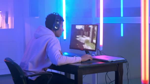 Pro gamer in oortelefoons spelen van online video game op personal computer — Stockvideo