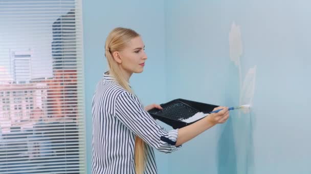 Mujer dibujando una flor en una pared azul — Vídeo de stock