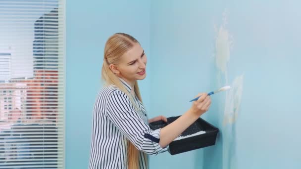 Vrouw die bloemen schildert op de muur. — Stockvideo