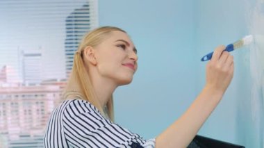 Duvara çiçek çizen kızın yakın plan fotoğrafı..