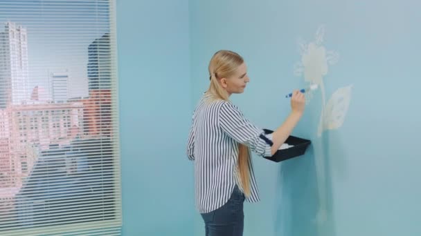 Vista posterior de flores de pintura femenina en la pared en la oficina . — Vídeo de stock