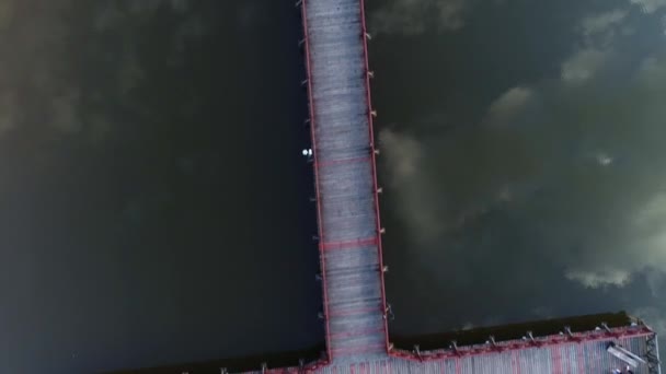 Blick von oben auf einen Holzsteg für Boote an einem sandigen Flussstrand. — Stockvideo