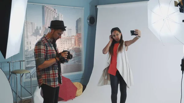 Modelul destul de negru face selfie pe smartphone în timpul fotografiei în studioul modern — Fotografie, imagine de stoc
