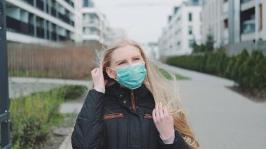 Sokakta yürürken maske takan bir kadın.