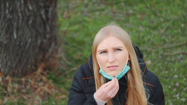 Female looking into the sky and putting on medical mask