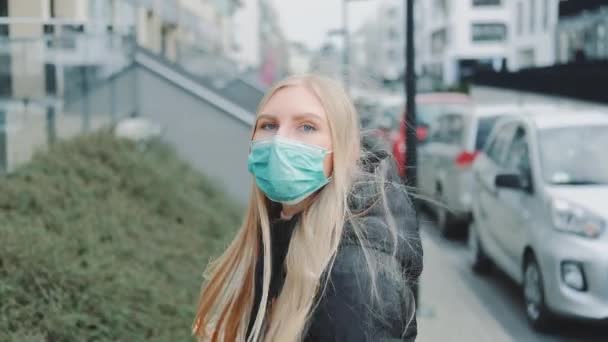 Frau mit medizinischer Maske auf der Flucht vor jemandem auf der Straße. — Stockvideo