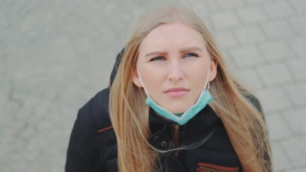 Mujer mirando al cielo y poniéndose máscara médica . — Vídeos de Stock