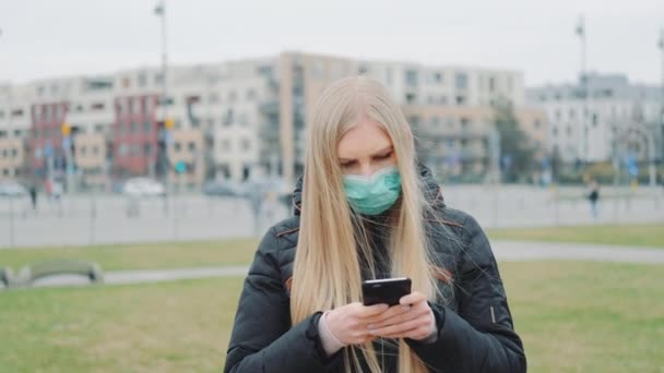 Orvosi maszkot viselő nő, aki friss híreket olvas a koronavírusbetegségről az utcán.