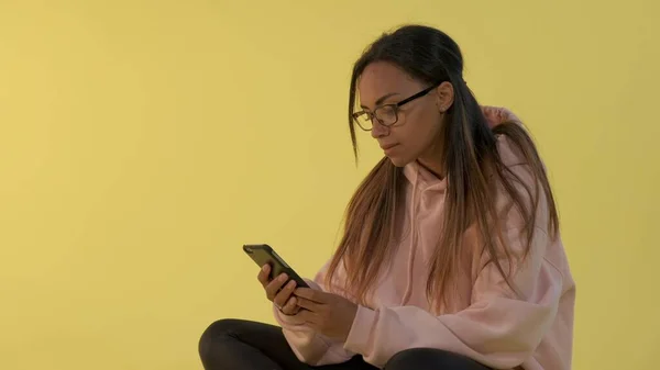 Närbild av svart kvinna i glasögon som arbetar på smartphone. — Stockfoto