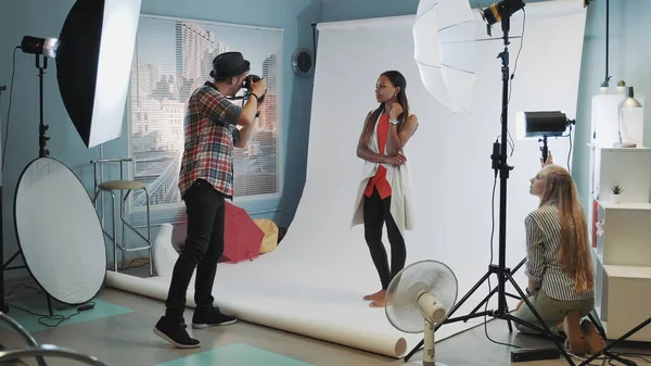 Backstage of the photo session in modern studio: assistant adjusting the spotlight on photo shoot — 스톡 사진