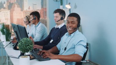 Uluslararası müşteriyle görüşerek yoğun çağrı merkezinde çalışan siyah müşteri destek ajanı