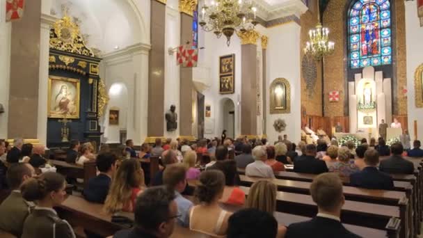 Mensen luisteren naar de preek in de katholieke kerk. — Stockvideo