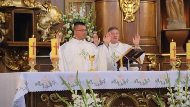 Dos sacerdotes están orando en la iglesia católica . — Vídeos de Stock