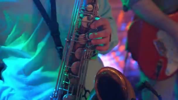 Jovem está jogando saxofone no clube . — Vídeo de Stock