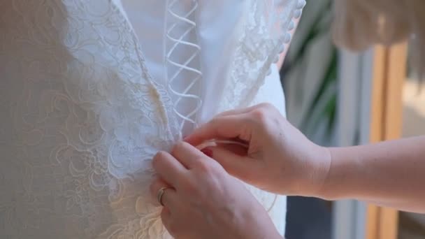 Mutter bindet das Korsett an das Kleid ihrer Tochter. — Stockvideo