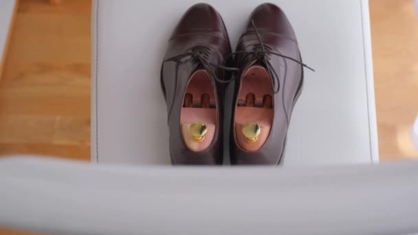 Свадебные туфли жениха лежат на стуле . — стоковое видео