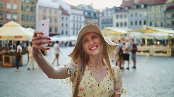Femme prenant selfie sur carré. Fille attrayante posant pour selfie et debout sur la place de la ville . — Photo