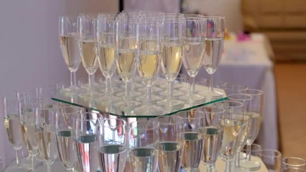 Sklenice se studeným šampaňským pro hosty na zrcadlovém podnosu. — Stock video