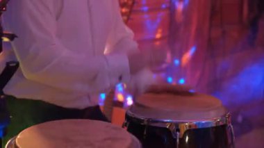 Adam ritmik olarak marakas çalıyor. Gece kulübü..