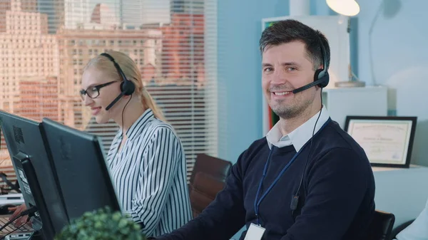 Handsome man service operator talking to the client on phone in call center — Stock Photo, Image