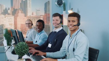 Medium shot of Diverse team of call center customers looking to the camera and smiling