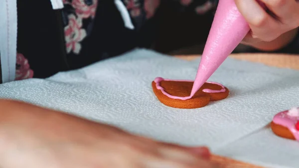 Processo di decorazione di biscotti a forma di cuore con glassa di zucchero rosa — Foto Stock