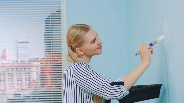 Nahaufnahme eines Mädchens, das Blumen an die Wand malt. — Stockfoto