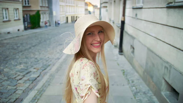 Woman gesturing follow me on street. Smiling young girl looking at camera and gesturing follow me on street.