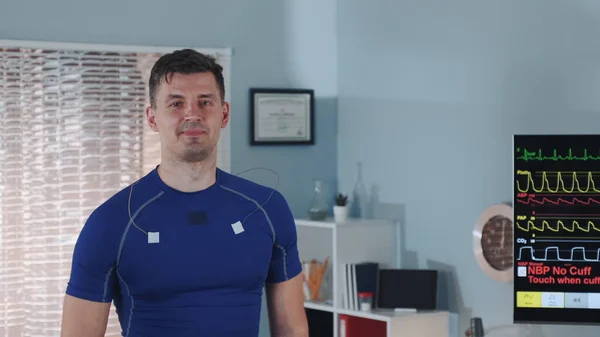 Close-up of handsome athlete walking on treadmill and smiling — Stock Photo, Image