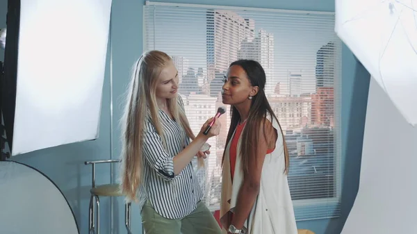 Behind the scenes on photo shoot: make-up artist preparing pretty black model to the photo shoot — 스톡 사진