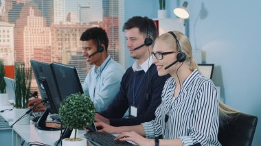 Güzel bayan müşteri hizmetleri uluslararası müşteriyle konuşarak yoğun çağrı merkezinde çalışıyor.