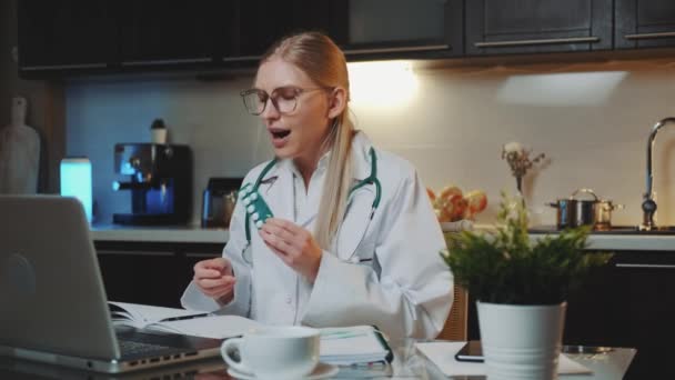 Videollamada al paciente: doctora en bata médica explicando cómo tomar medicamentos — Vídeos de Stock