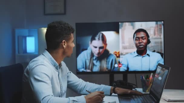 Close-up de gerente chefe preto fazendo videochamada no monitor grande com colegas em quarentena — Vídeo de Stock