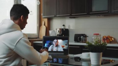 Siyahi adam bilgisayardaki kadın doktorla video görüşmesi yapıyor.