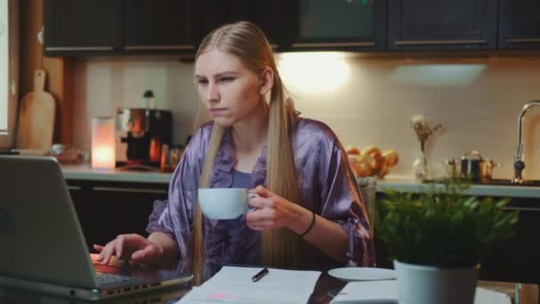 Working at home: Busy woman in home bathrobe drinking a cup of coffee — Stock Video