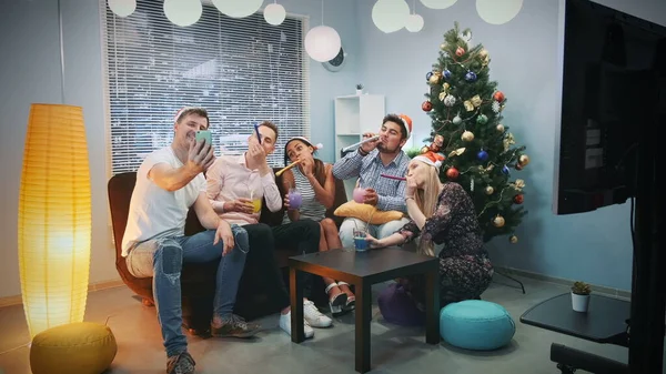 Jóvenes de raza mixta en los sombreros de Santa haciendo videollamada por teléfono inteligente en la fiesta de Navidad —  Fotos de Stock