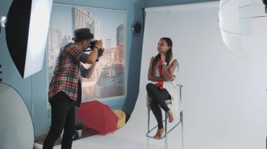 Moda dergisi için yüksek sandalyede poz veren çekici melez bir model..