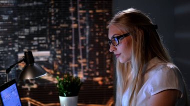 Gece geç saatlerde internette kitap arayan genç bilim kadınlarının yakın çekimi.