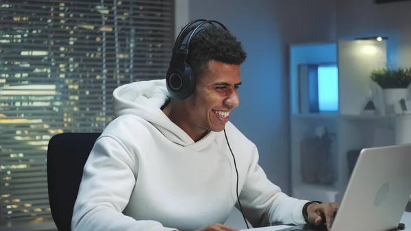 Gamer in headphones winning online game on computer