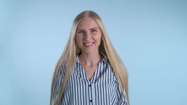 Dudaklarını ısıran ve gülümseyen çekici genç bayan.