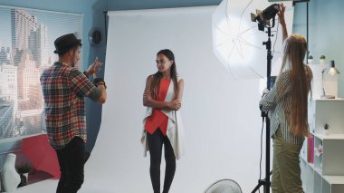 Profesyonel fotoğrafçı modern stüdyoda fotoğraf çekiminin organizasyonel anlarını anlatıyor.