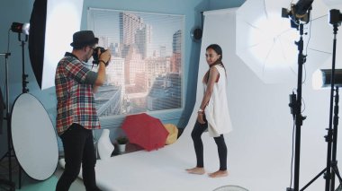 Profesyonel stüdyo fotoğraf çekiminde fotoğrafçıya poz veren güzel melez kız.