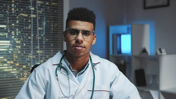 Genç Afrikalı doktorun kameraya bakıp akşamları bir şeyler anlattığı yakın plan.