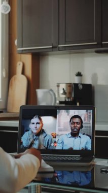Karantinada çalışan çok ırklı meslektaşlar bilgisayar tarafından ortak video çağrısı yapıyorlar.