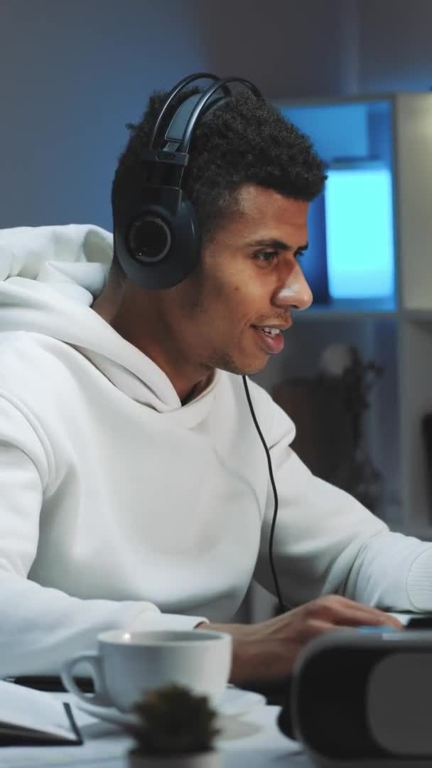 Close-up tiro de Black gamer com capuz branco e com fones de ouvido jogando jogos no computador à noite — Vídeo de Stock